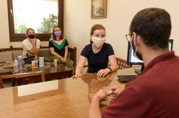 Masked girl talking to an employee