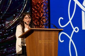 Girl speaking in the microphone on the podium 