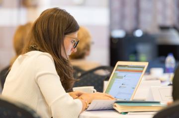 Woman writing in front of her laptop