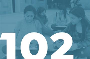 Girls studying together on campus. 102 written on the image in white