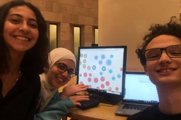 students smiling by the computer