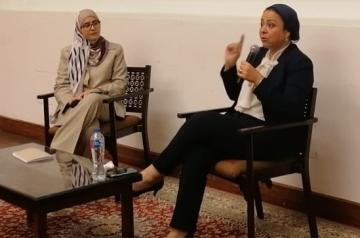 two ladies sitting next to each other in a panel discussion