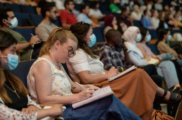 Graduate Student taking notes in Bassily Hall