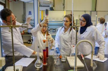 Female students in a lab with faculty