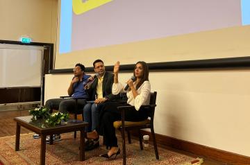 three panelists on sitting on stage