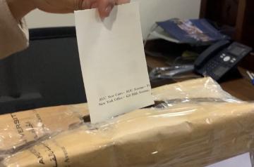 Picture of box with hand putting a paper inside