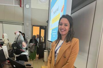 A smiling girl wearing a suit in classroom