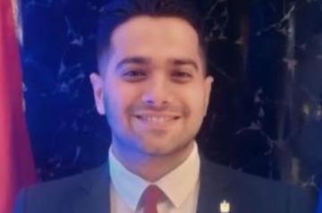 A man wearing a suit and smiling