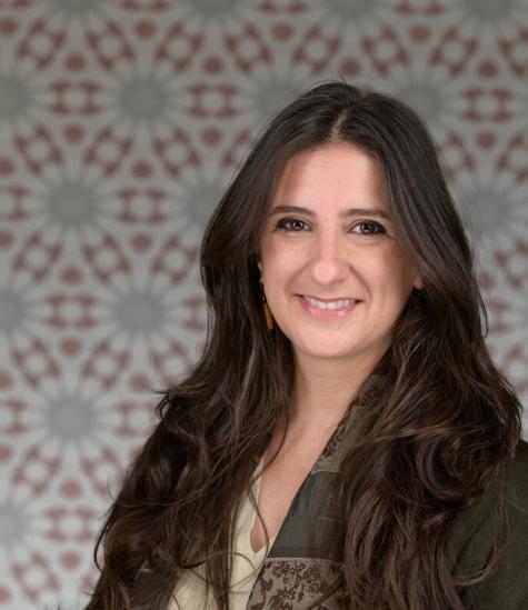 A woman smiling in front of decorated background