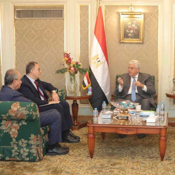 A group of four men and one women meeting in an office