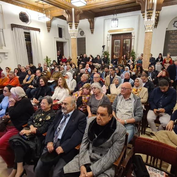 People in a hall sitting and watching performance on stage