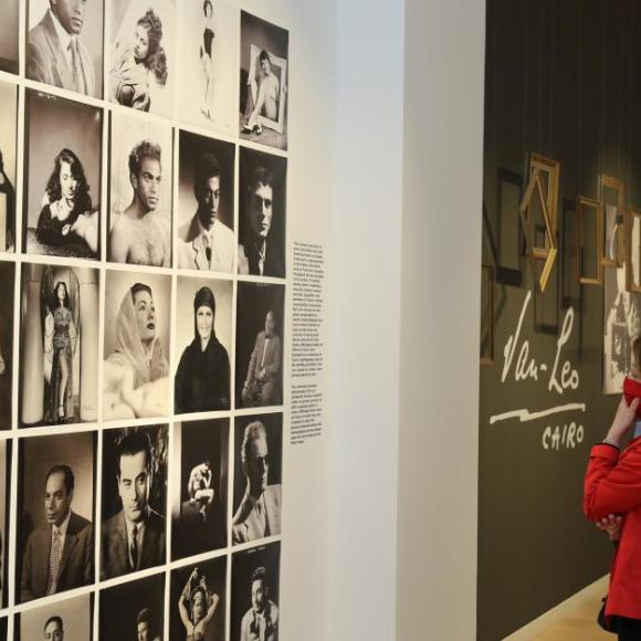 Lady and man looking at wall with art photos