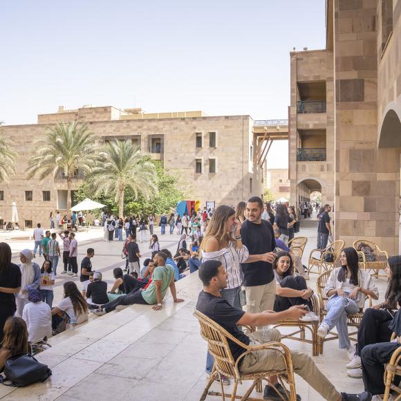 Students sitting under SSE building socializing