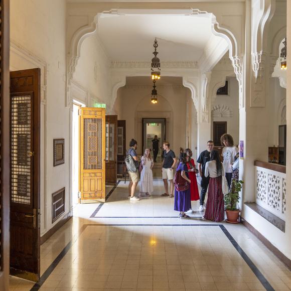 A group of students in a hallway with wooden doors