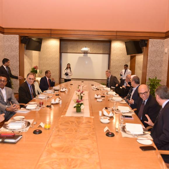 A group of men sitting around a conference table wearing suits and ties