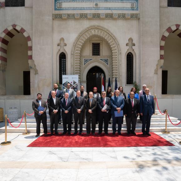 A group of people standing outside a building wearing suits