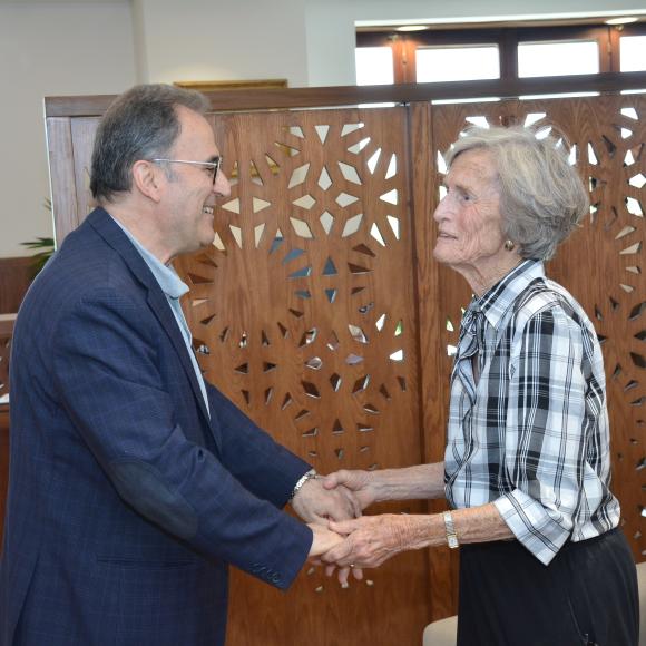president ahmad dallal standing with an old lady with white hair Anne Kerr