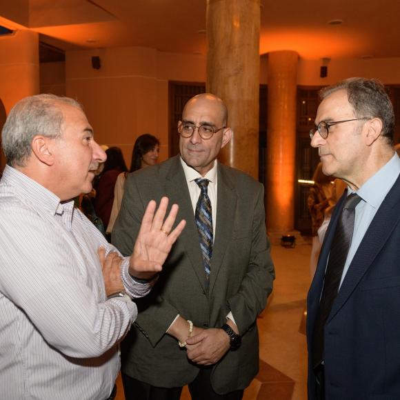 Three men standing and talking together