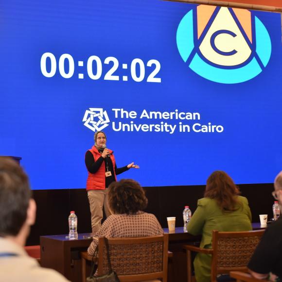 A woman is talking in front of a panel of judges