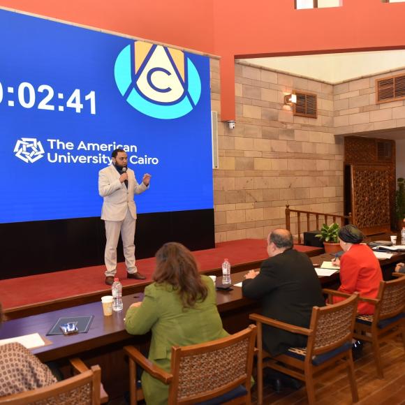 A man is talking in front of a panel of judges