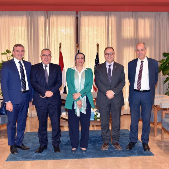 Four men and a woman standing together for a group photo