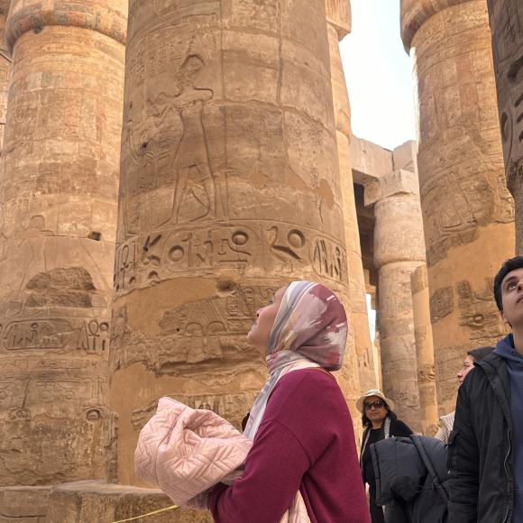 Woman looks up at a pillar