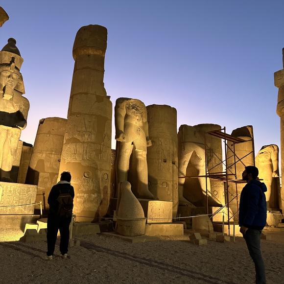 Pillars of a temple are lit up in the dusk