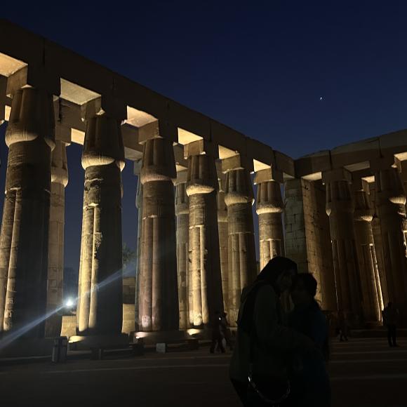 A row of pillars are lit up in a dark landscape