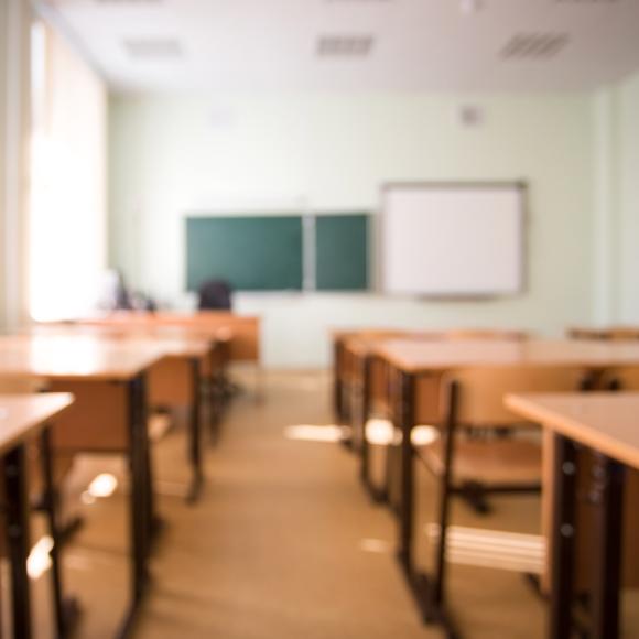 an empty classroom with desks and chairs and a clean white board