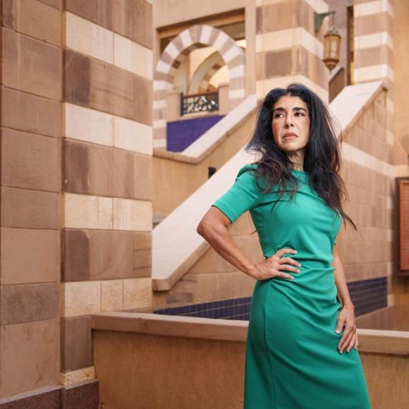 A woman is standing, she has one hand on her waist