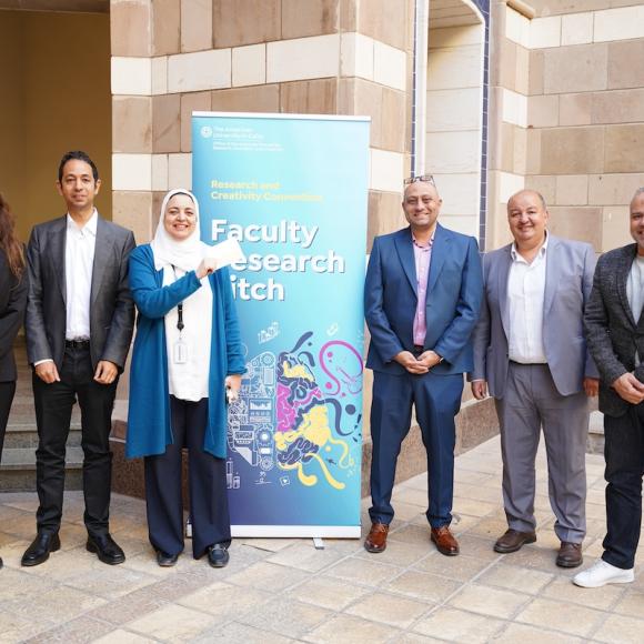 A group of people standing beside a banner.