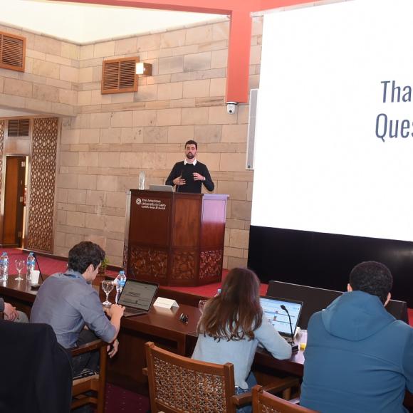 A man is talking in front of a panel. Text: Thank You. Questions?