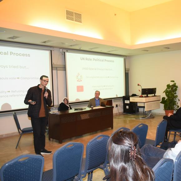 A man is talking into a microphone in front of an audience