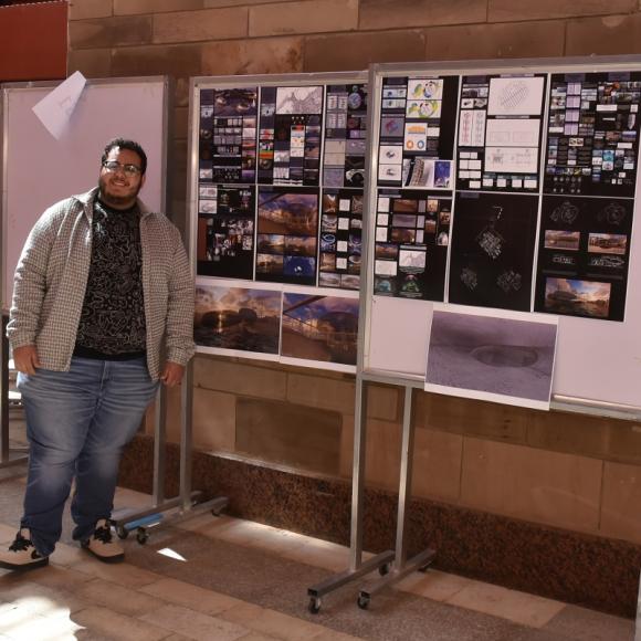 A male is standing next to two boards