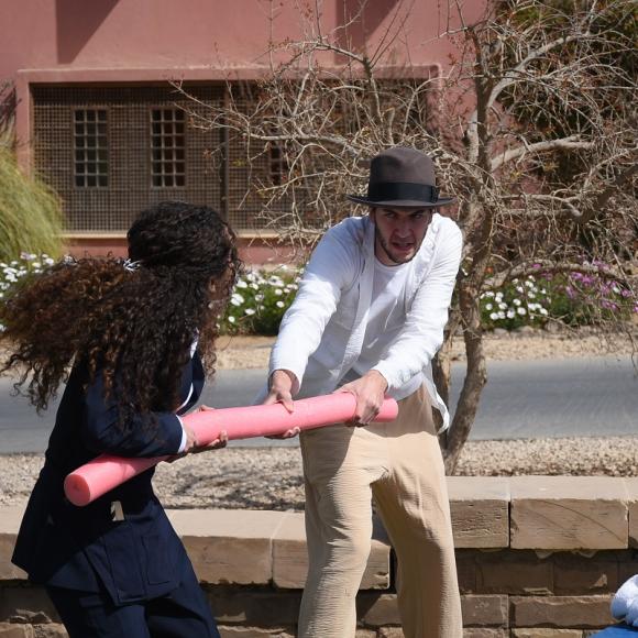A male is pilling a floating spaghetti from a female. They are acting.
