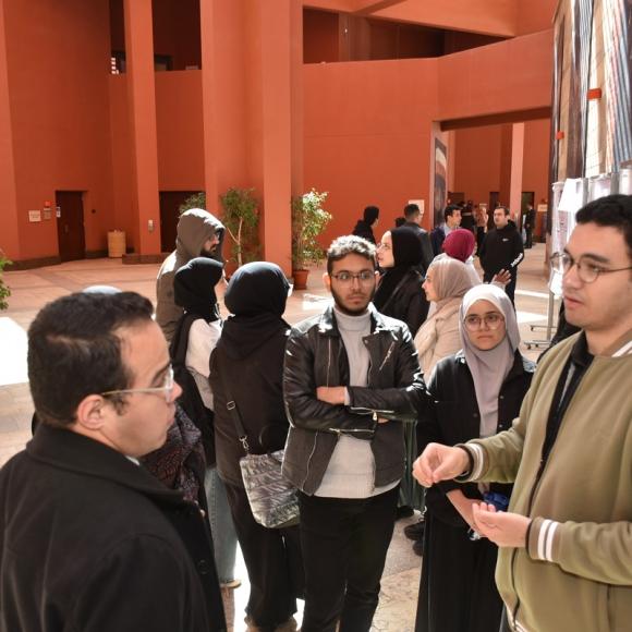 Males and females are standing in front of boards and talking