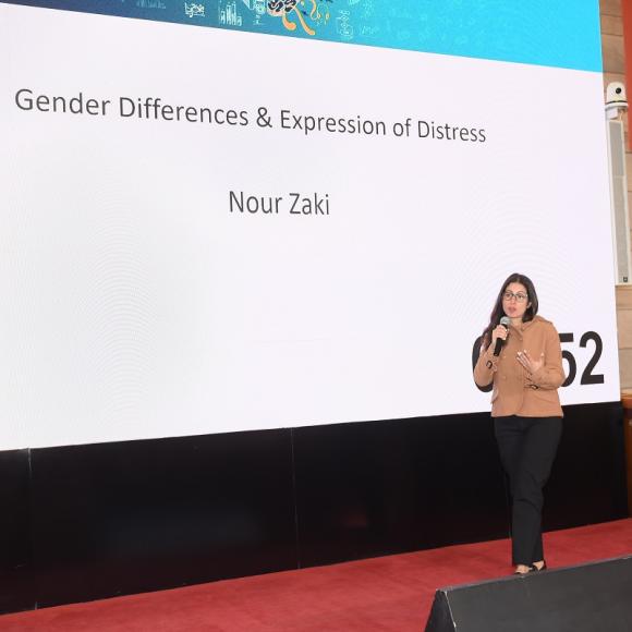 A woman is talking into a microphone. Text: Gender Differences and Expression of Distress