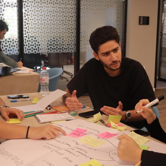 a group of students wearing black tshrits sitting at a table doing an activity