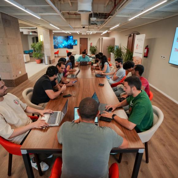a gorup of students sitting on a table at auc innovation hub work stations