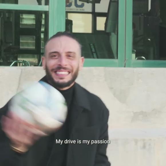 a footballer holding a football in his hand and smiling