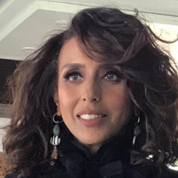 a woman with short brown hair with brown eyes smiling
