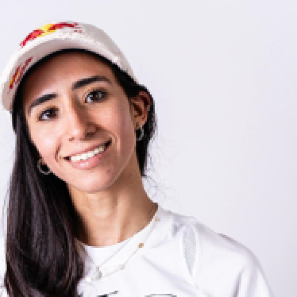 a headshot of a girl with long black hair wearing a cap