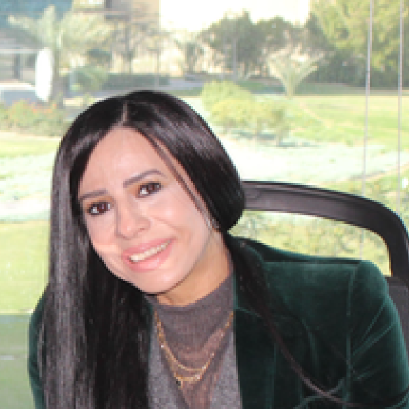 a headshot of a woman with long black hair wearing a black blazer