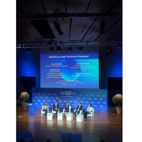 A group of panelists sitting on separate chairs onstage
