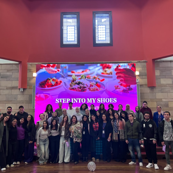 All participants standing in front of the "step into my shoes" banner