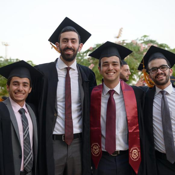 A group of undergraduate men pose for a photo at commencements